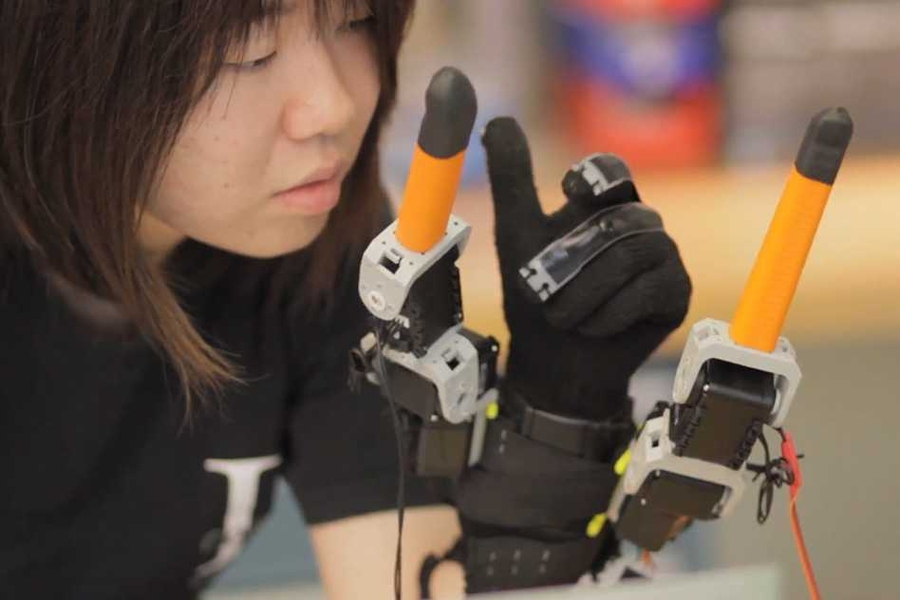 Faye Wu, a graduate student in mechanical engineering, demonstrates the "supernumerary robotic fingers" device