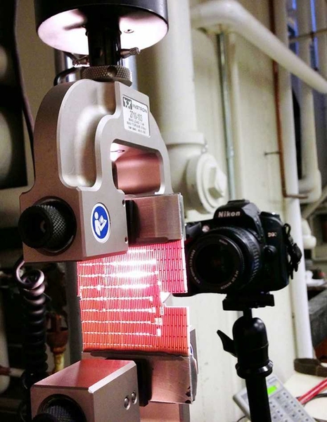 A 3-D printed composite with bone-like topology is deformed in an Instron machine. A backlight helps highlight the deformation and fracture mechanisms.