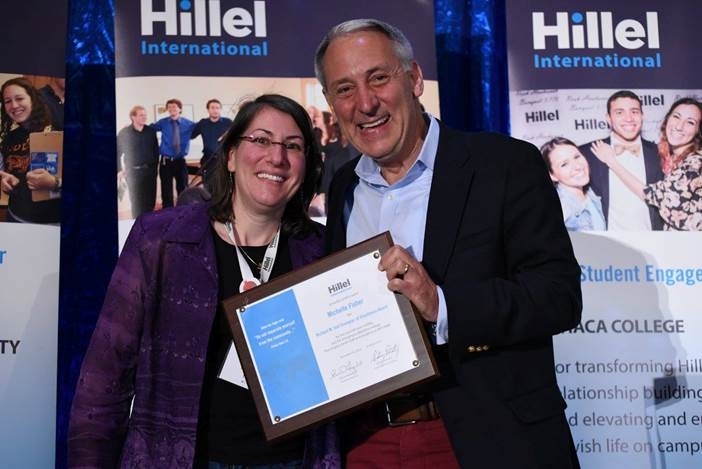 Hillel International CEO and president Eric Fingerhut presents Rabbi Michelle Fisher SM ’97 with a 2014 Richard M. Joel Exemplar of Excellence Award at the Hillel International Global Assembly in Orlando, Fla.