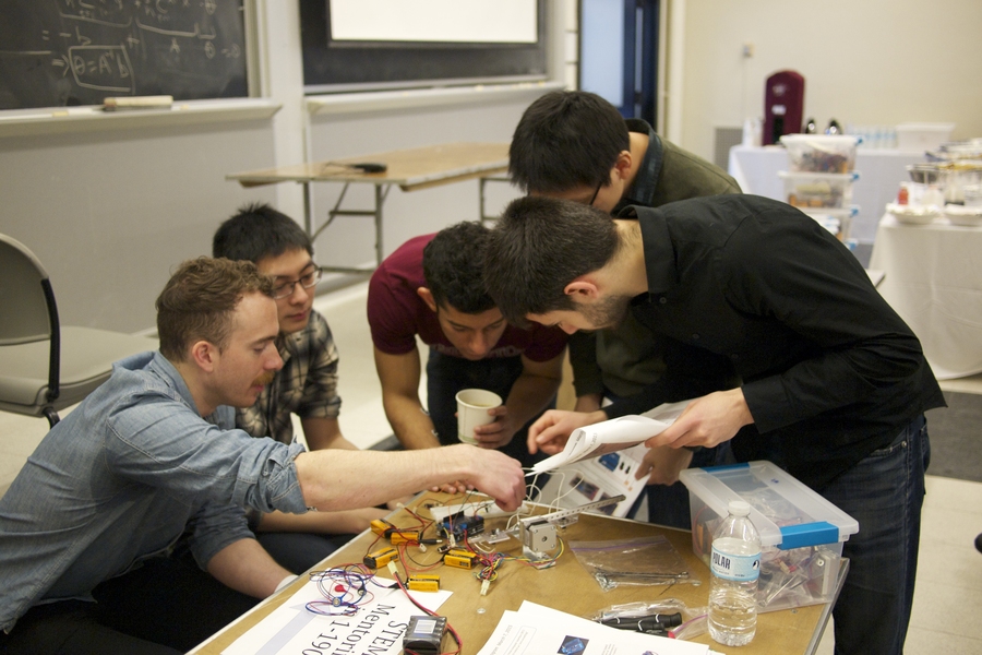 Left to right: University of Washington graduate student Matthew Sample and MIT graduate students Haowei Su, Aalap Dighe, Dan Wu, and Theodore Golfinopoulos demonstrate the correct setup of the circuit and robotic arm.