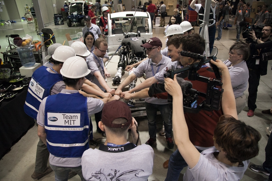 Members of the MIT DARPA Robotics Challenge team huddle before their first run.