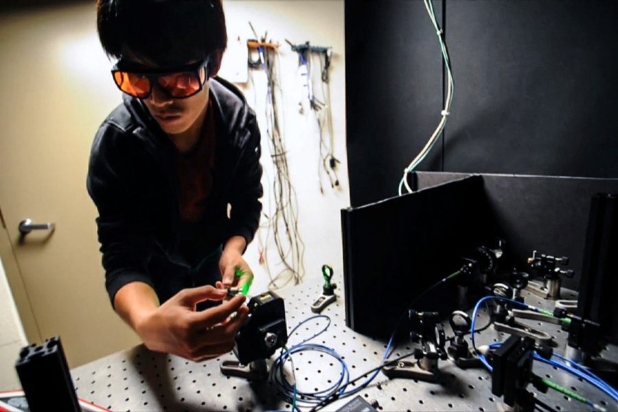 Researchers have designed a feedback-control system for maintaining quantum superposition that requires no measurement. Masashi Hirose (pictured) adjusts optical components on the the setup used to perform the experiment.