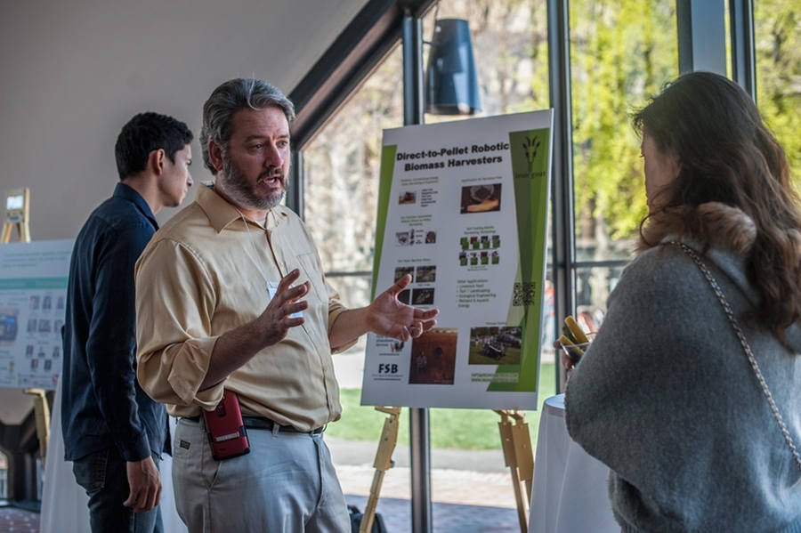 Jason Force of Iron Goat, which won two top prizes at the competition, explains his team's idea to an attendee during an innovation showcase.