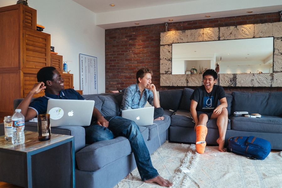 Left to right: MIT seniors Mohamed “Hassan” Kane, Guillermo Webster, and Kevin Kwok work on their startup projects at the “Sandcastle” in San Francisco. The orange cast on Kwok’s leg is the result of a trampoline accident, and has inspired plenty of teasing from his MIT housemates.