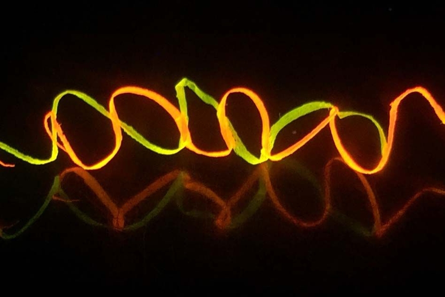 A photograph shows regenerated helical silk fibers colored by Rhodamine dyes, under UV light.