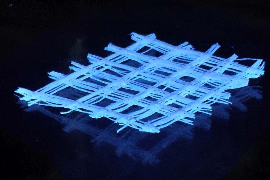 A photograph of a regenerated 3-D silk fiber mat under UV light.