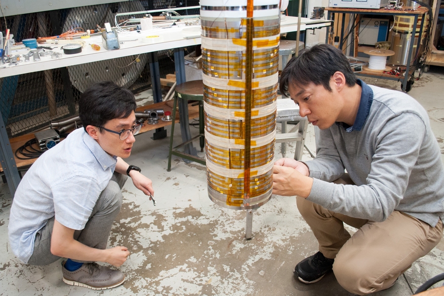 Assisted by postdoc Jiho Lee, Dongkeun Park inspects the wiring of a completed HTS coil in preparation for testing it in liquid helium.