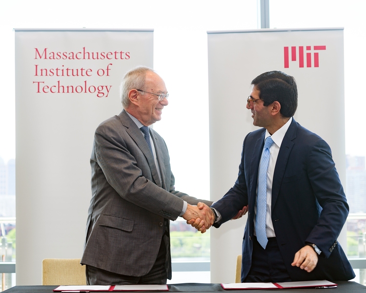 MIT President L. Rafael Reif (left) and Talal Shair shake hands to commemorate the collaboration between the Dar Group and MIT.