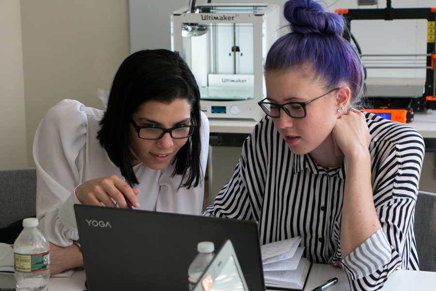 Fashion Institute of Technology 2018 graduate Veronica Apsan (left) and rising MIT senior Erika Anderson collaborate on a new fabric design at MIT. Behind them are 3-D printers used by participants in a Workshop in Advanced Functional Fibers and Fabrics, held for the first week at MIT and the second week at FIT.