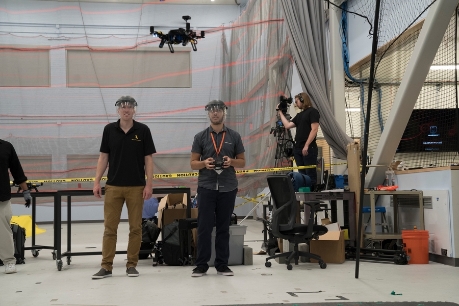Autonomous Air Vehicle Racing instructor Ross Allen and student Christopher Evagora look on as an autonomous vehicle completes its flight around the course.