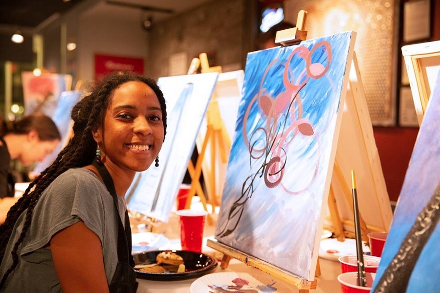 A grad student works on her painting.