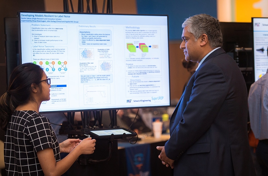 EECS senior Roshni Sahoo (left), an Angle SuperUROP scholar, describes her research project to Anantha Chandrakasan, dean of the School of Engineering. Chandrakasan developed SuperUROP in 2012, when he was EECS department head.