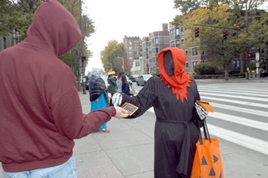 Grim Reaper Meg Westlund of the Center for Educational Computing Initiatives hands out candy and a reminder about the Community Giving campaign at 77 Massachusetts Ave.