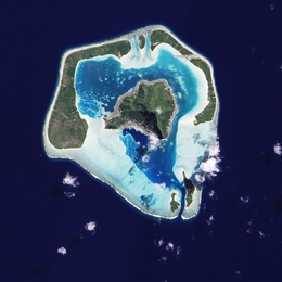 A satellite image of Maupiti, one of the Society Islands, which is on its way to becoming an atoll. Submerged reef appears in pale blue.