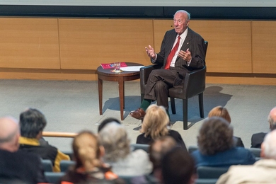 George Shultz seated in front of an audience
