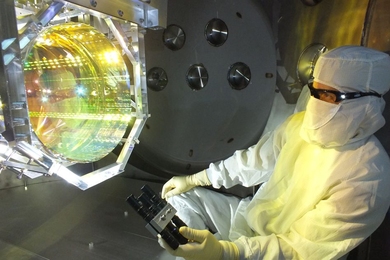 MIT physicists have observed that LIGO’s 40-kilogram mirrors can move in response to tiny quantum effects. In this photo, a LIGO optics technician inspects one of LIGO’s mirrors.