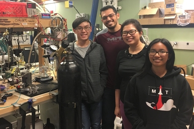 Four MIT researchers standing smiling in a lab