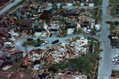 Aerial photo of houses devastated by hurricane winds; parts of the walls and roofs of houses have been torn off.