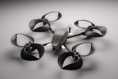 A small black drone outfitted with four toroidal propellers. Each propeller looks like two loops, made of plastic.