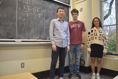 Photo of Yufei Zhao, Tomasz Ślusarczyk, and Dain Kim standing in front of a blackboard.