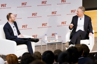 Bryan Landman (left) and Ken Griffin sit on opposite sides of a small coffee table, conversing onstage at the Wong Auditorium. A backdrop with MIT logos is behind them.