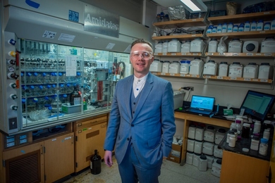 Portrait photo of Bradley Pentelute standing in a chemistry lab