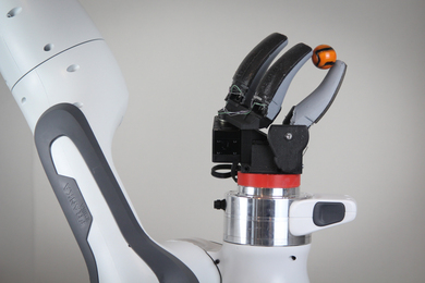 A robotic hand with finger-shaped sensors grabs an orange marble.
