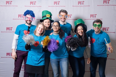 Seven young people wearing identical 2019 GetFit T-shirts celebrate in novelty hats and glasses