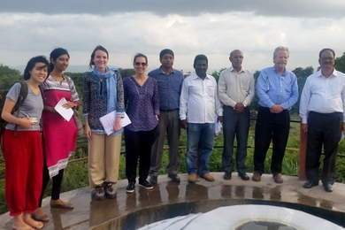 The team poses at a waterworks in Maharashtra, India, with local partners.