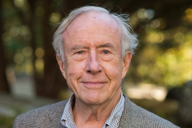 Portrait photo of George Clark wearing a blazer over an open-collar shirt, looking directly into the camera