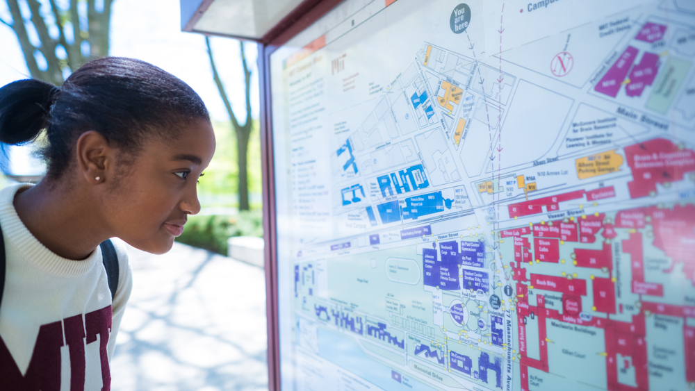 MIT student looks at university map outside