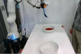 Una mano robótica intenta recoger canicas rojas y colocarlas en otro recipiente, mientras que la mano de un investigador interfiere con frecuencia en ello.  El robot finalmente lo consigue.