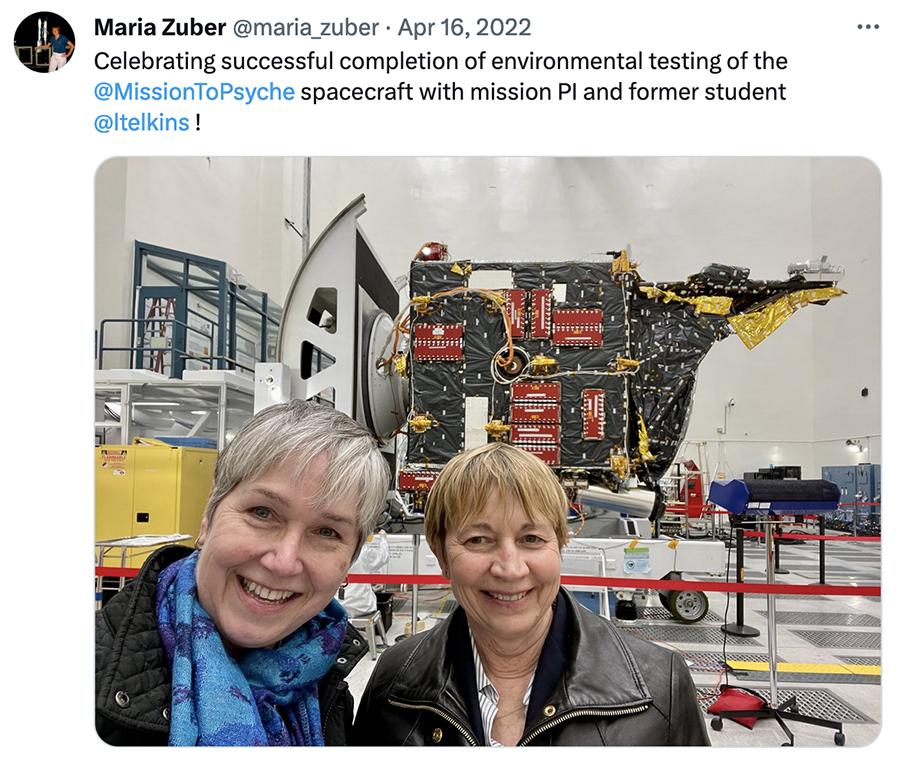 Tweet with a selfie taken by Lindy Elkins-Tanton and Maria Zuber in a large cleanroom where a large spacecraft appears behind them. Text via @maria_zuber: Celebrating successful completion of environmental testing of the @MissionToPsyche  spacecraft with mission PI and former student @ltelkins!