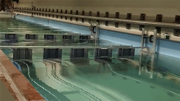 Animation of rippling water that move through two sets of artificial reef structures, which resemble bridges.