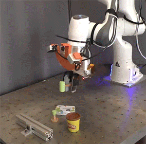 机械臂使用玩具锤的动画，物体被随机放置在其周围。