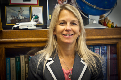 Dava Newman in front of a bookshelf