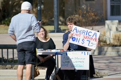 People advocate for a higher minimum wage per hour in downtown Boulder, Colorado.