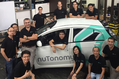 The nuTonomy team, including Emilio Frazzoli (third from left, standing), with one of their driverless cars