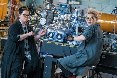 Abby Yates (Melissa McCarthy, left), a gung-ho scientist with expertise in the paranormal, and Jillian Holtzmann (Kate McKinnon, right), an eccentric engineer, tinker in a nearly perfect replication of an MIT lab.