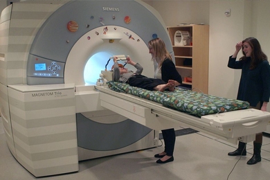 MIT graduate student Hilary Richardson helps a child into an MRI scanner for a study of how children's brains develop the ability to think about the mental states of other people.