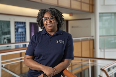 Chiamaka Agbasi Porter smiles for a photo standing in the Lincoln Laboratory lobby.