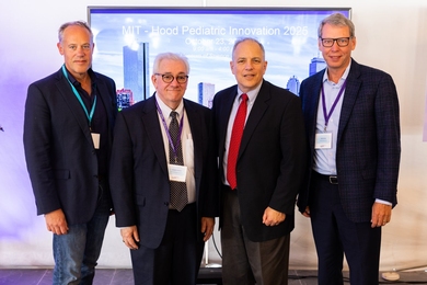  John Parker Jr., Joe Frassica, Elazer Edelman, and Neil Smiley pose in front of a poster for “MIT-Hood Pediatric Innovation 2025"