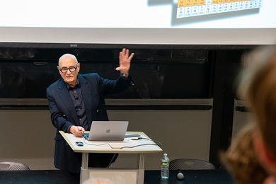 Diran Apelian stands at a lectern, gesturing while speaking to an audience