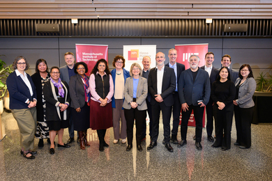 16 people pose for a photo in front of banners for Massachusetts Institute of Technology and Hasso Platner Institute