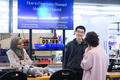 Three people talking in a lab. A screen behind them says "How to Fingerprint (Raman) Almost Any Material"