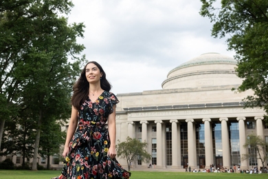 Amanda Burcroff, wearing a floral print dress, stands outside the MIT Dome