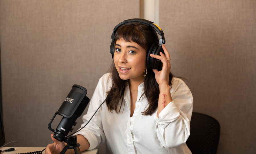 Photo of Jessica Chomik-Morales wearing headphones and seated in sound booth.