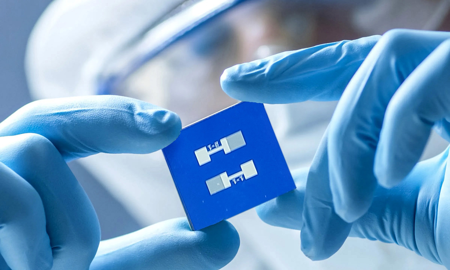 A lab worker holding a sensor chip