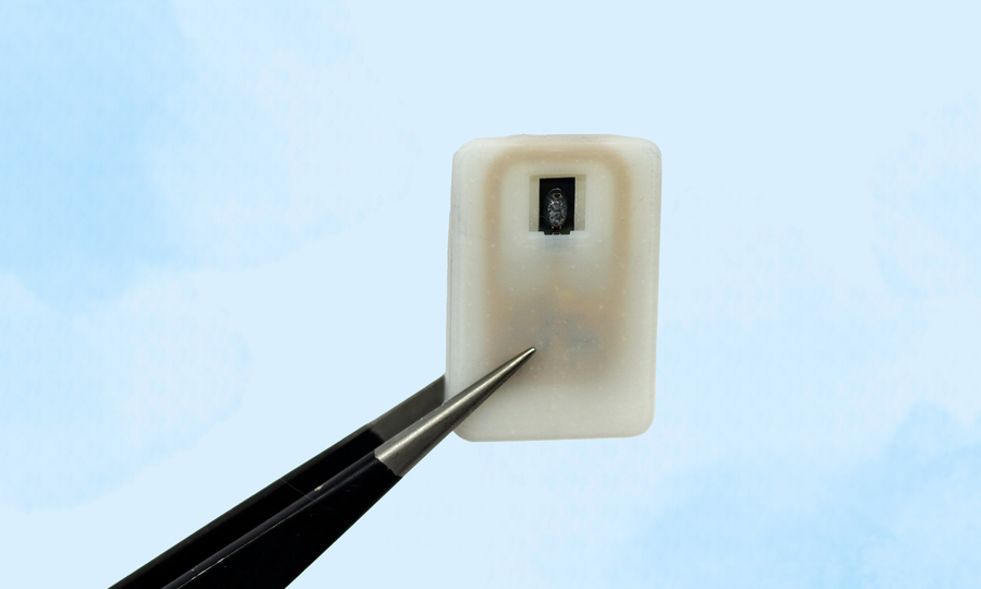 An implantable device held by tweezers
