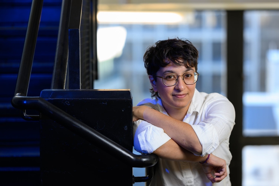 Palak Patel poses in a stairwell, leaning on a railing